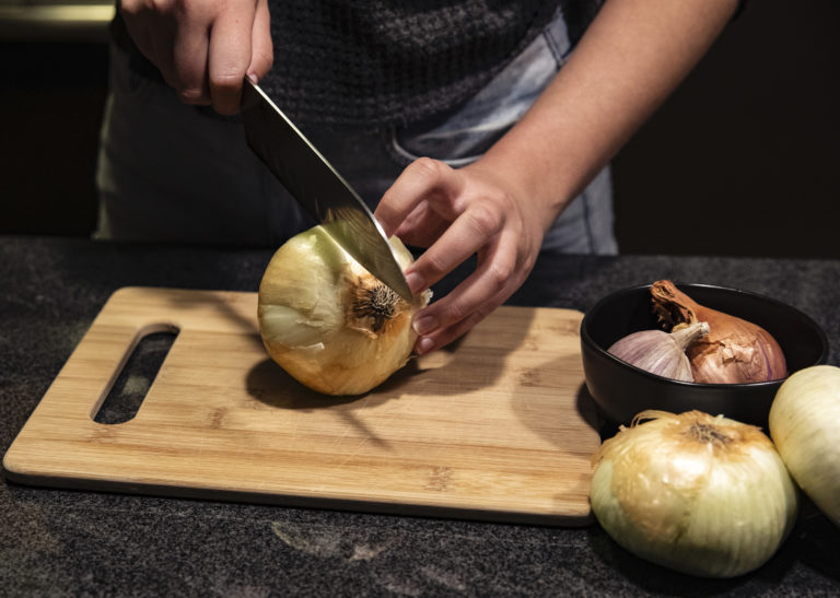 Chopping an onion on a cutting board